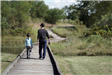 Man and Girl Walking on Boardwalk