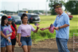 Veteran Handing a Young Woman a Flag