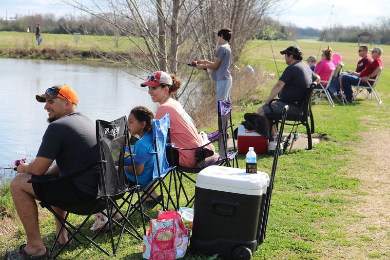 Family Sitting Beside Lake